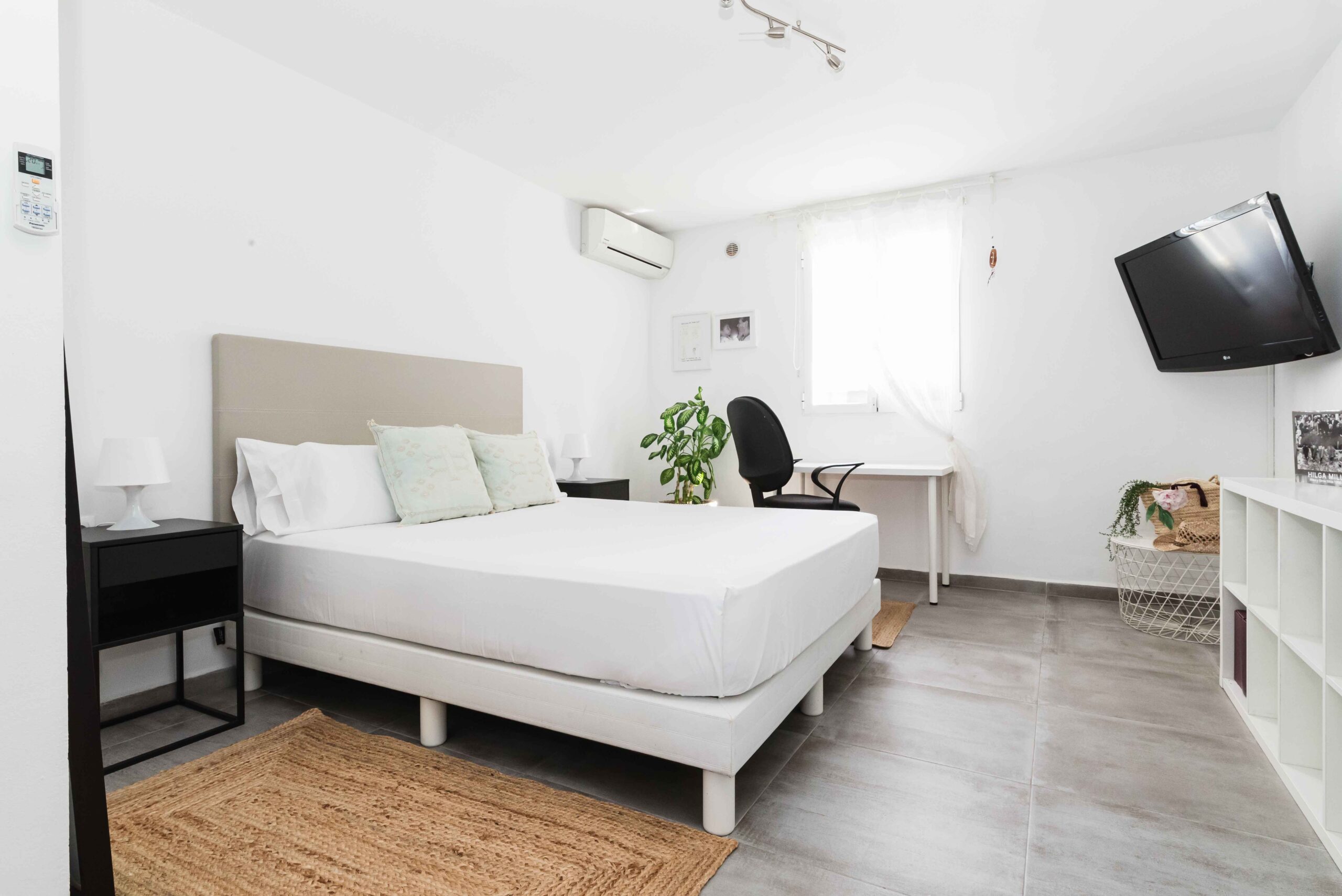 Dormitorio con cama doble, decoración en tonos claros y luz natural