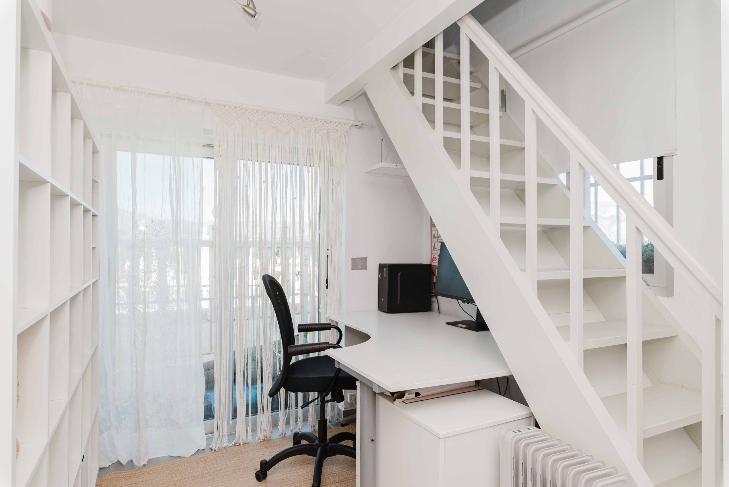 Zona de trabajo con escritorio, silla y luz natural junto a ventana