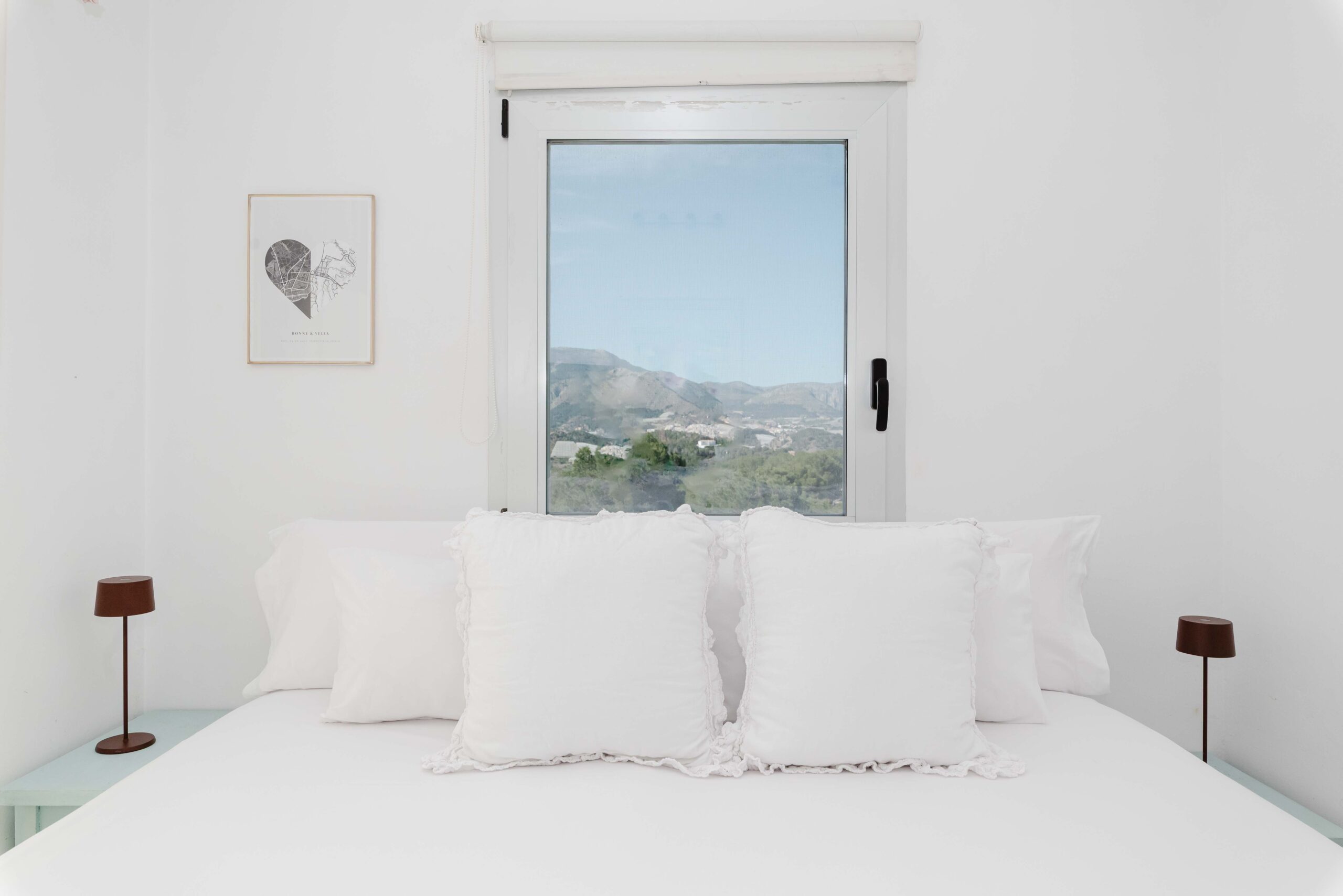 Dormitorio principal luminoso con cama doble, decoración en tonos claros y luz natural